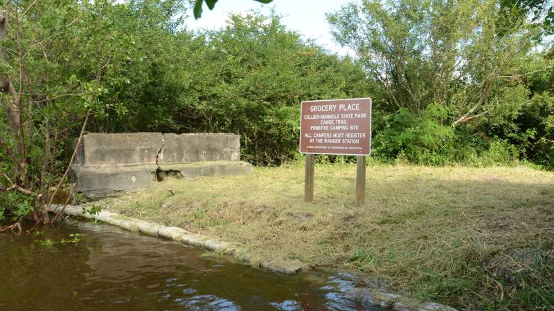 water grass and brown sign